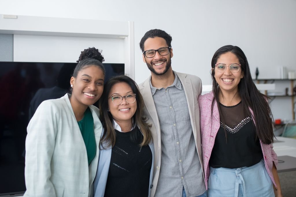 Four smiling colleagues in an office